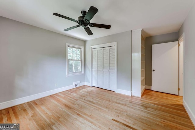 unfurnished bedroom featuring visible vents, ceiling fan, baseboards, light wood-style floors, and a closet