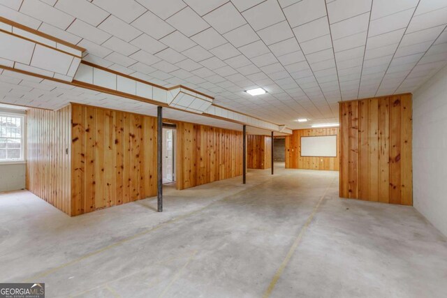 basement featuring wooden walls