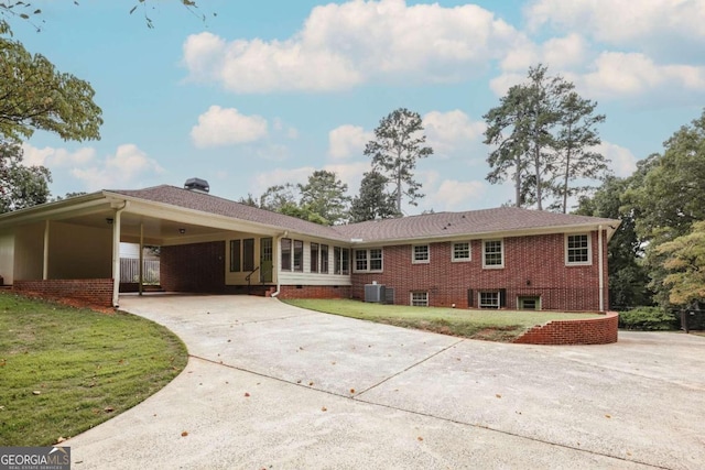 exterior space with a front lawn, a carport, and central air condition unit