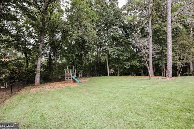 view of yard featuring a playground and fence