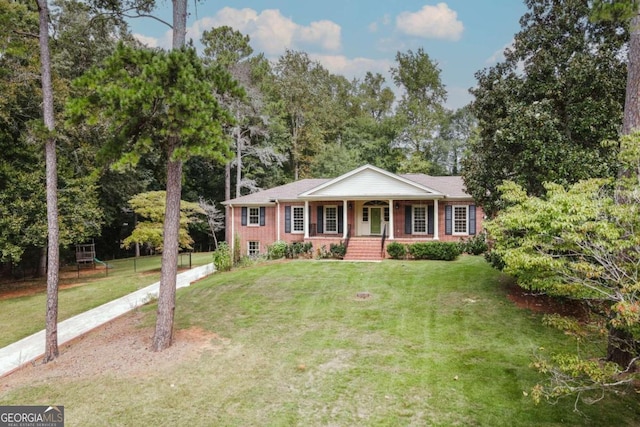 view of front of house with brick siding, covered porch, and a front yard