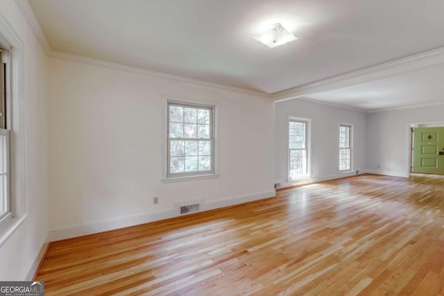 spare room featuring visible vents, light wood-style flooring, and crown molding