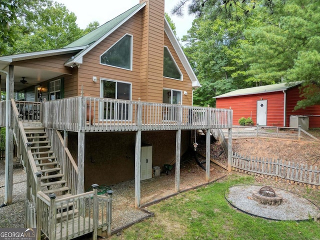 rear view of property with a fire pit, a deck, ceiling fan, and a shed