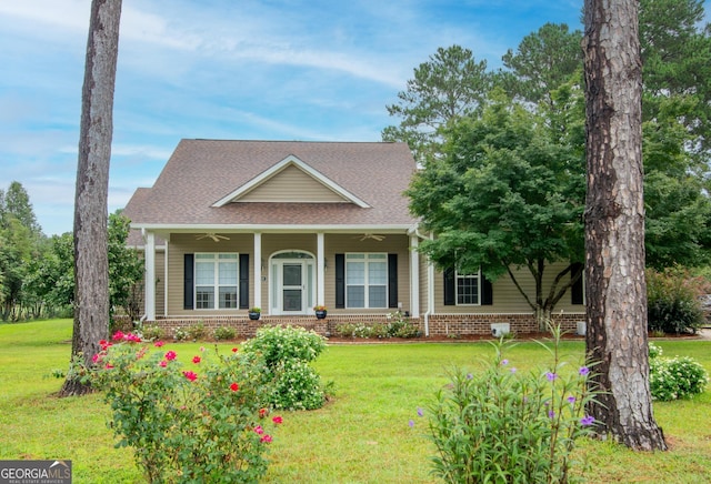 view of front of house featuring roof with shingles, a porch, ceiling fan, a front lawn, and brick siding