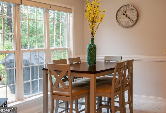 dining area with baseboards and marble finish floor