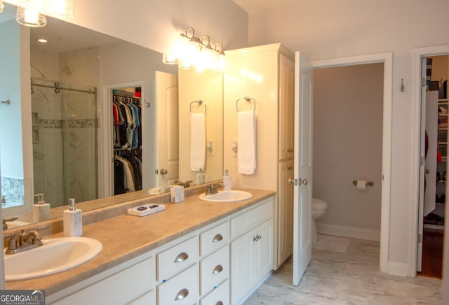 bathroom featuring a sink, a walk in closet, and marble finish floor