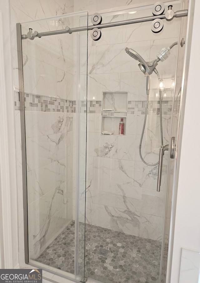 bathroom featuring a marble finish shower