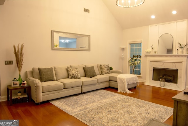 living room featuring visible vents, high vaulted ceiling, wood finished floors, a high end fireplace, and recessed lighting