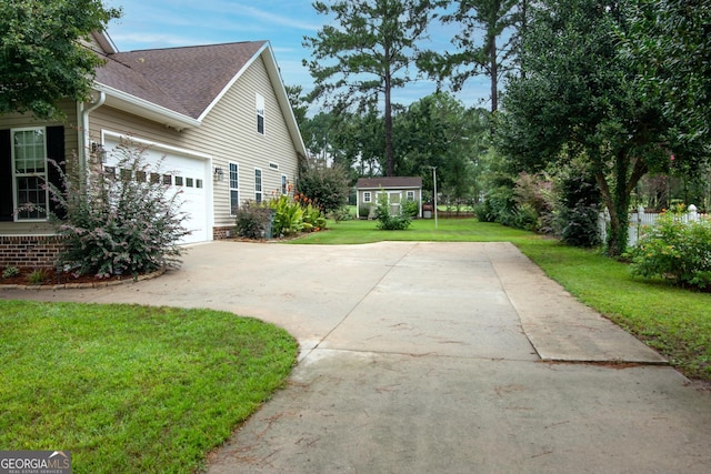 view of side of home with a garage, a lawn, roof with shingles, and concrete driveway