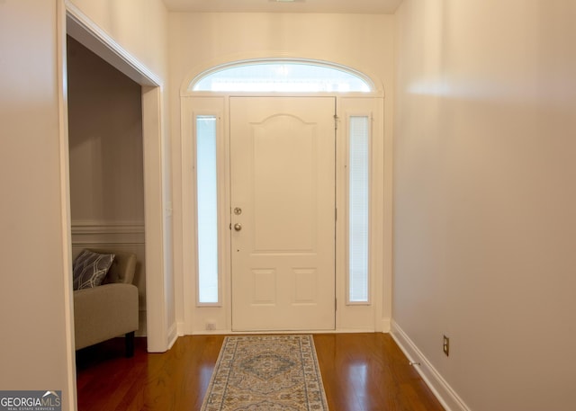 foyer with dark wood finished floors and baseboards