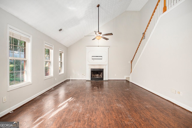 unfurnished living room with dark hardwood / wood-style flooring, a healthy amount of sunlight, ceiling fan, and a textured ceiling