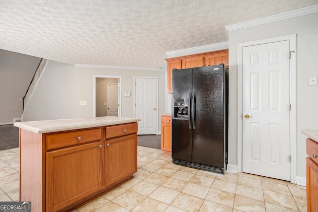 kitchen featuring crown molding, light tile patterned flooring, a kitchen island, black refrigerator with ice dispenser, and a textured ceiling