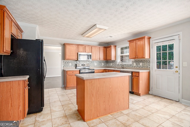 kitchen with a center island, stainless steel appliances, a textured ceiling, and ornamental molding