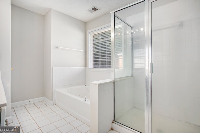 bathroom with a textured ceiling, independent shower and bath, and tile patterned floors