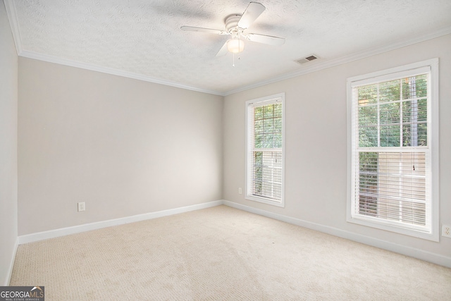 carpeted spare room with a textured ceiling, ceiling fan, and ornamental molding