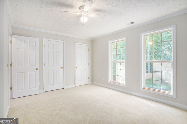 unfurnished bedroom featuring ceiling fan, light carpet, and multiple windows