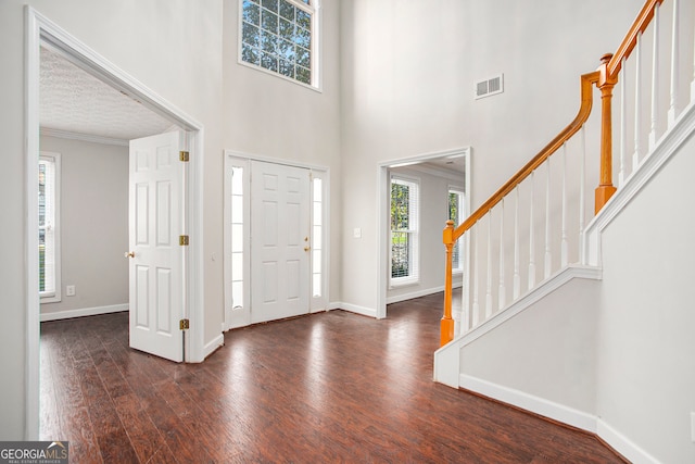 entryway with crown molding and dark hardwood / wood-style floors