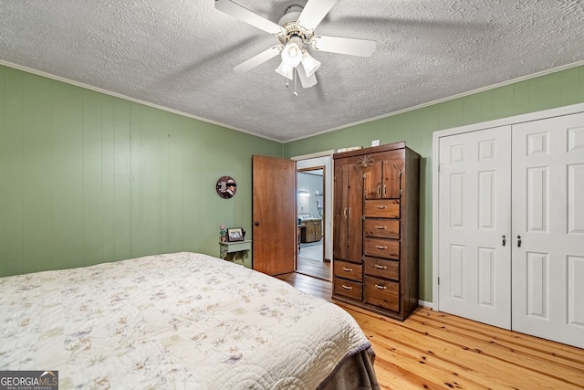 bedroom featuring a textured ceiling, crown molding, ceiling fan, and light hardwood / wood-style floors