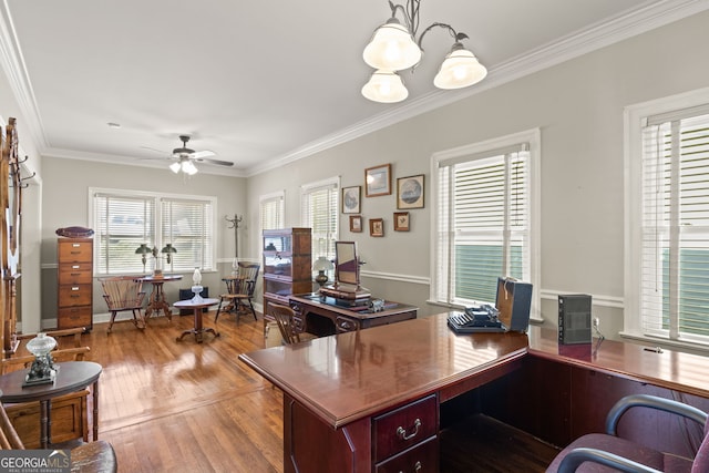 office featuring ceiling fan with notable chandelier, wood-type flooring, a wealth of natural light, and ornamental molding