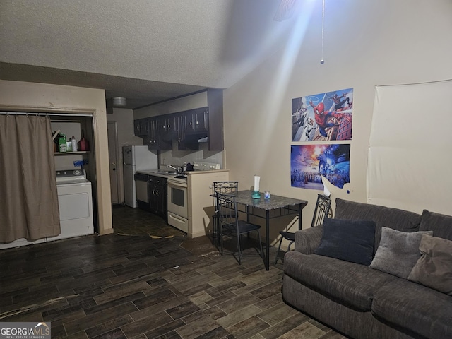 living room with dark wood-type flooring, washer / dryer, and a textured ceiling