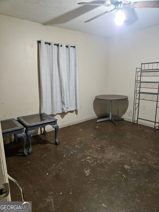 miscellaneous room with ceiling fan and a textured ceiling