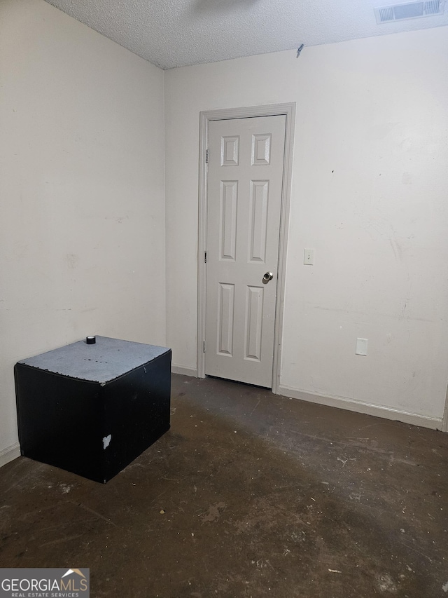 unfurnished room with a textured ceiling