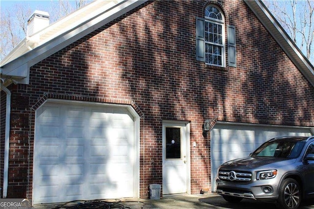 view of front facade with brick siding and a chimney