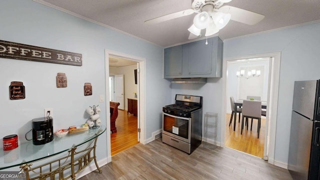 kitchen featuring crown molding, ceiling fan with notable chandelier, appliances with stainless steel finishes, light hardwood / wood-style floors, and a textured ceiling