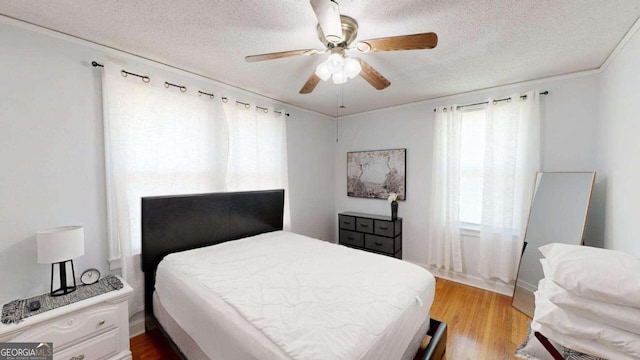 bedroom with a textured ceiling, ceiling fan, and hardwood / wood-style flooring