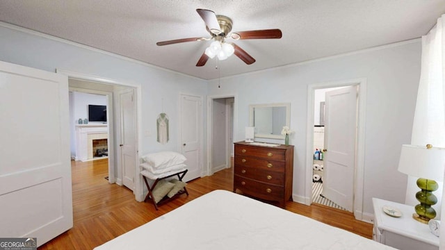 bedroom with a textured ceiling, ceiling fan, and hardwood / wood-style flooring