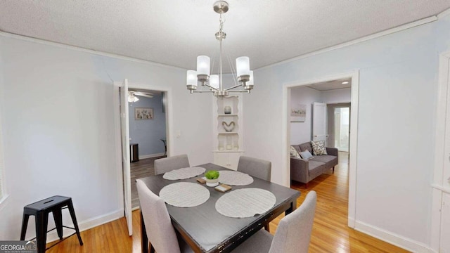 dining space with ceiling fan with notable chandelier, a textured ceiling, and light hardwood / wood-style flooring