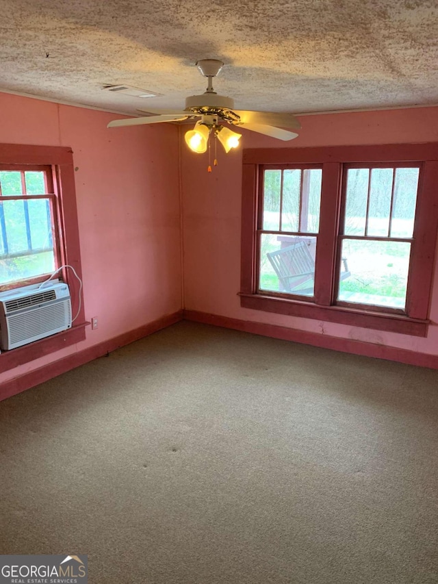 carpeted spare room with ceiling fan, a textured ceiling, and a healthy amount of sunlight