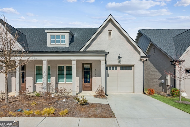 view of front of property featuring a shingled roof, brick siding, driveway, and an attached garage