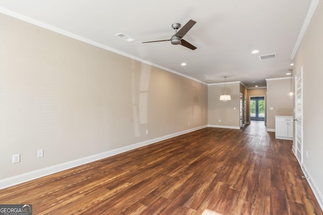 unfurnished living room with crown molding, visible vents, dark wood-type flooring, ceiling fan, and baseboards