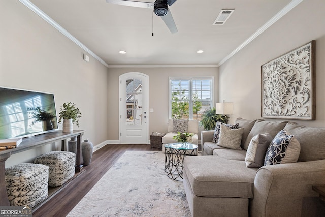 living room featuring baseboards, visible vents, ceiling fan, dark wood-type flooring, and crown molding