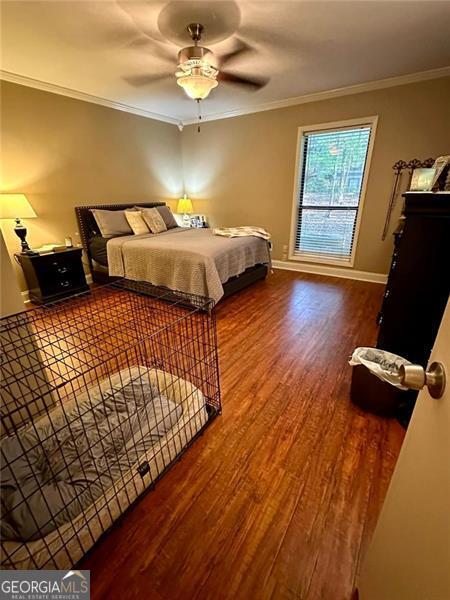 bedroom with wood-type flooring, ceiling fan, and ornamental molding