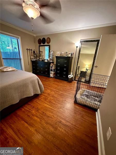 bedroom featuring ornamental molding, hardwood / wood-style flooring, and ceiling fan