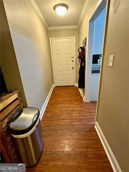 hallway featuring hardwood / wood-style flooring and crown molding