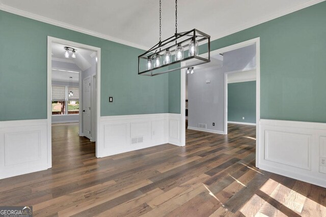 unfurnished dining area with dark wood-type flooring and ornamental molding