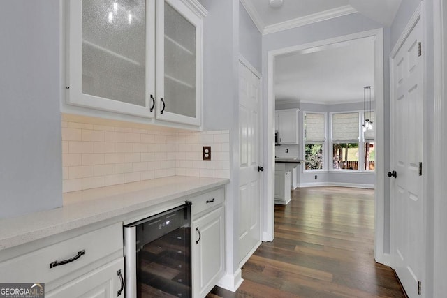 bar featuring decorative backsplash, wine cooler, light stone counters, crown molding, and white cabinetry