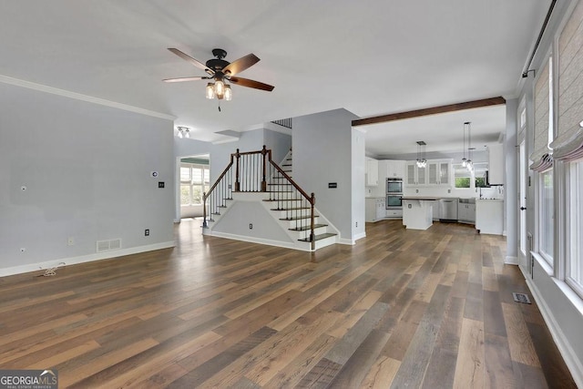 unfurnished living room with a wealth of natural light, dark hardwood / wood-style flooring, and ceiling fan