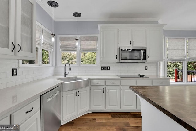 kitchen with appliances with stainless steel finishes, backsplash, white cabinetry, and sink