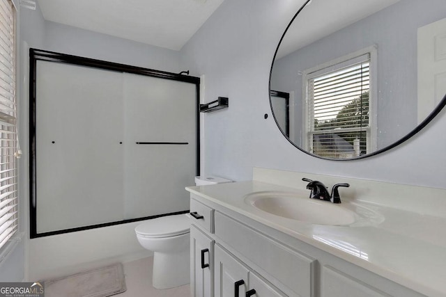 full bathroom featuring tile patterned floors, vanity, toilet, and combined bath / shower with glass door