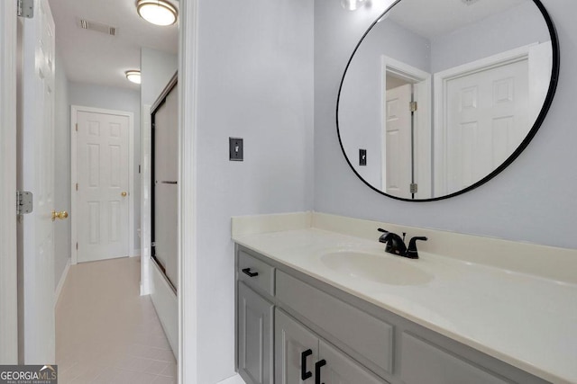 bathroom with tile patterned floors, shower / bath combination with glass door, and vanity