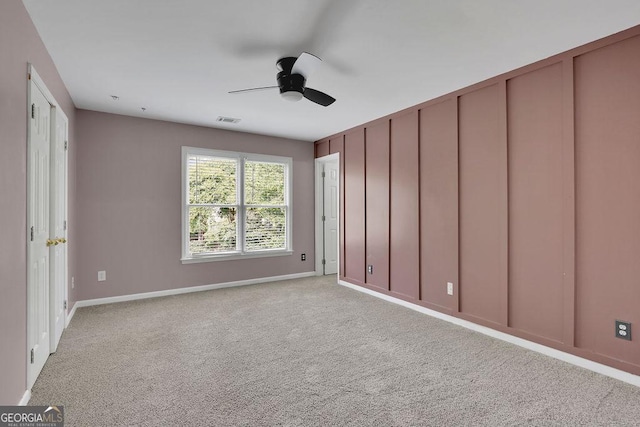 carpeted spare room featuring ceiling fan