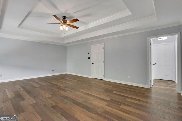 unfurnished room with dark hardwood / wood-style flooring, a tray ceiling, ceiling fan, and crown molding