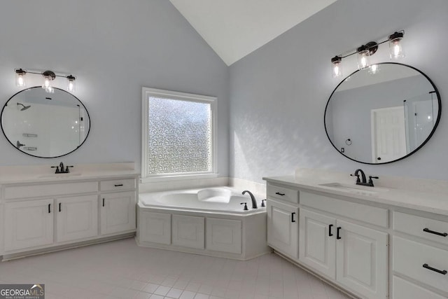 bathroom featuring tile patterned floors, a tub, vanity, and lofted ceiling