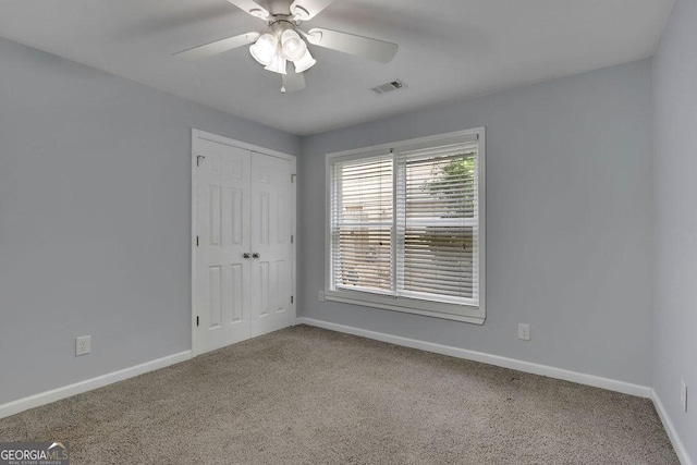 carpeted spare room with ceiling fan