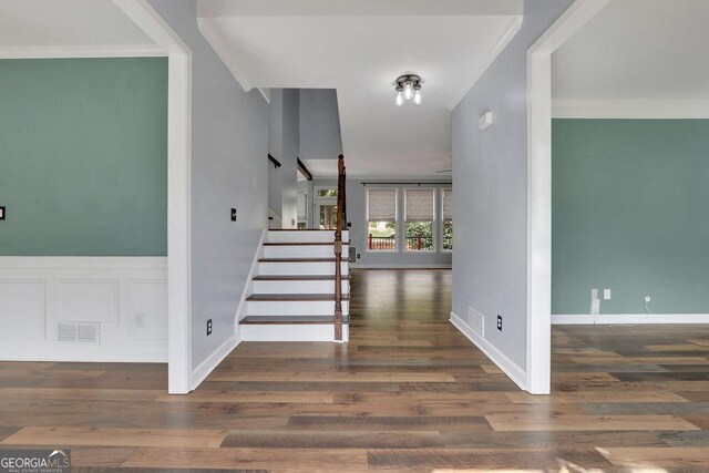 stairway featuring wood-type flooring and crown molding