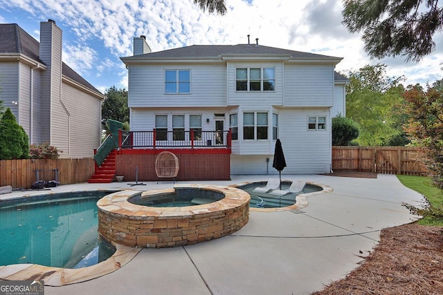 back of house with a patio and a pool with hot tub